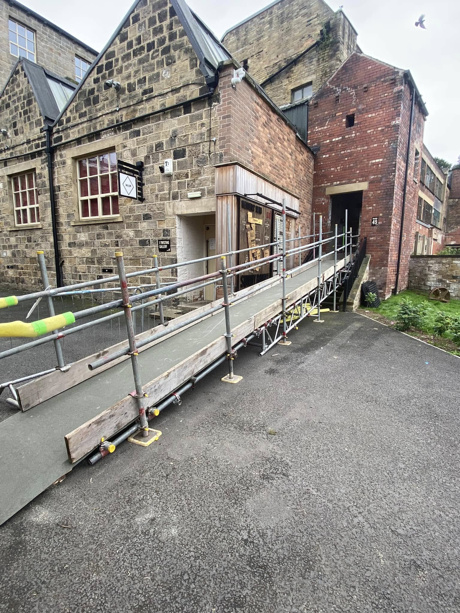 Scaffold access ramp built over steps to a building entrance in Leeds